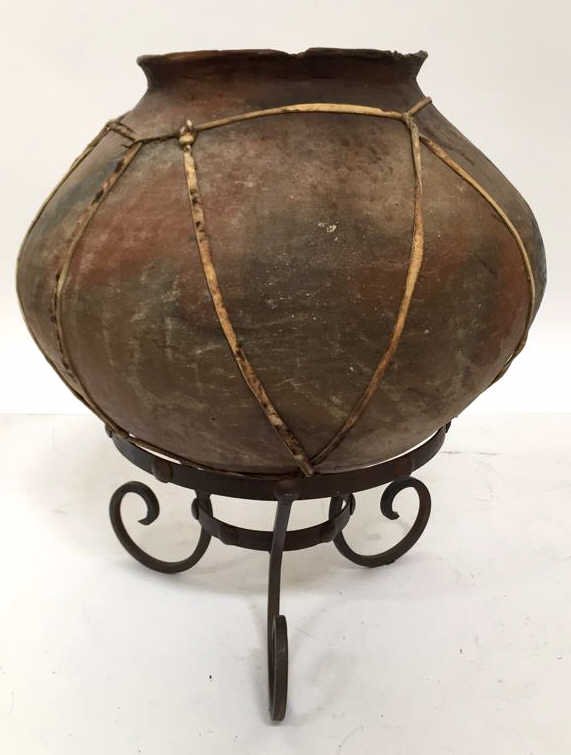 Wrought Iron Planter Base Gourd Pot Rustic terra cotta: Rustic terra cotta urn shaped pot wrapped in leather string worn and chipped at rim. Measures 20h x 17 in diameter. Planter ring is 12 in diameter.