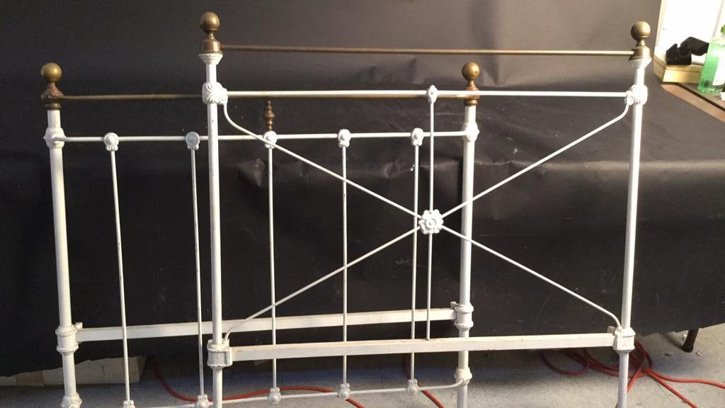 Vintage Iron and Copper Twin Bed Frame: Vintage iron and copper twin sized bed frame. Railed. Painted white. Slight floral motif. Head board measures 42 inches high by 46 inches wide. For board measures 50 inches high