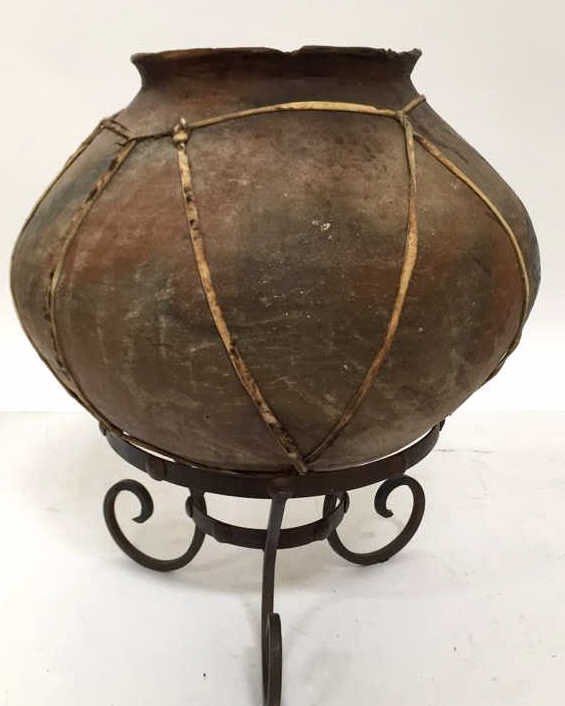 Wrought Iron Planter Base Gourd Pot: Rustic terra cotta urn shaped pot wrapped in leather string worn and chipped at rim. Measures 20h x 17 in diameter. Planter ring is 12 in diameter.