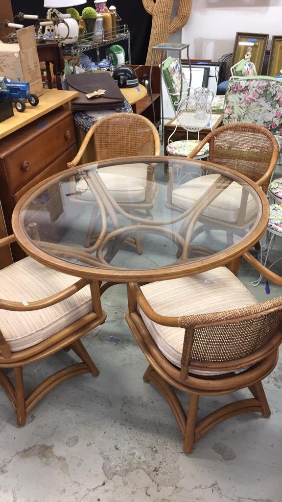 Veranda Lanai Dining Table 4 Swivel Armchairs: Round glasses pedestal table with four splayed legs.