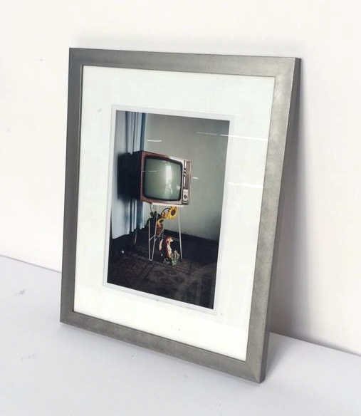 Metal Framed Nick Waplington Photograph: Lot includes 7x10 photograph by Nick Waplington in a metal edged frame, measurements of the photograph with the frame in inches 13.5x16.25, frame and photograph in good condition, labeled Nick Wapling
