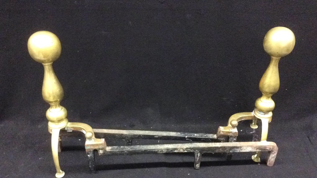 Pair of Brass and Iron Andirons: Pair of brass and iron andirons measure 29 inches long by 18 inches high.