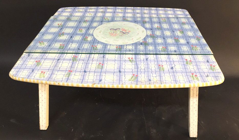 JEANNE VAN ETTEN Hand Painted Drop Leaf Table: Plaid repeat floral design periwinkle with white ground pink green and yellow polka dots. Glass top in closed position. Splayed wood legs. Measures open 21 x 35 x 35