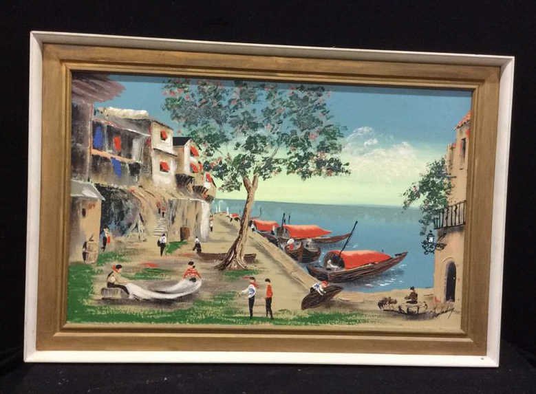 Illegibly Signed Water Scene Oil Painting: Town/water scene oil painting in a gold and white frame measuring in inches 45x30, signed illegibly in the bottom right corner, wire in the back for hanging, painting and frame in great condition