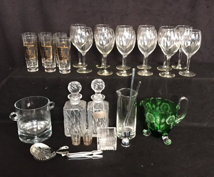 32 Piece Vintage Glass & Crystal Bar Lot: Lot includes 6 glasses with gold and black emblems written New York 1956 measuring in inches 7H, 12 Crystal wine glasses measuring 8.5H, 1 glass ice bucket, 2 Crystal decanters with stoppers 1 has chi