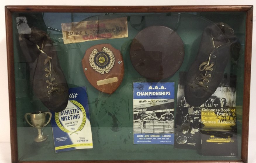Shadow Box Of Vintage English Athletic Memorabilia: Collection of vintage British athletic memorabilia encased in wooden shadow box. Items include athletic shoes, official programs from 1955 Athletic Meeting in White City and 1962 A.A.A. Championships 