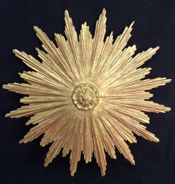 Gilt Starburst Carved Wood Wall Hanging: Carved wood Wall hanging in Starburst form a Sunburst form . Center carved medallion each ray of multiple fanned pieces differing and alternating lengths. All gold leafed. Very decorative artwork scul