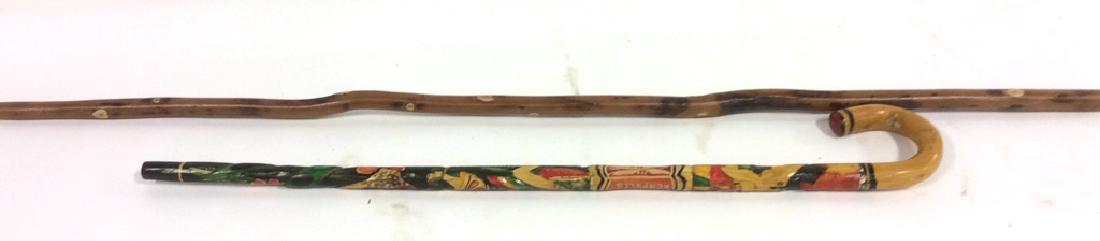 Wooden Walking Stick and Cane: This group lot consists of an Adirondack Style walking stick, and a cane carved with a Mayan design. The Adirondack Style Walking Stick measures 44 inches tall and inch and half thick. The Mayan desig
