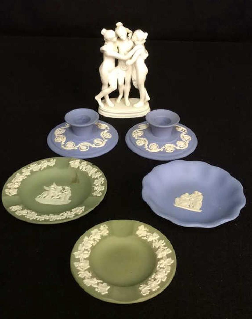 5 Pieces Wedgewood England & Figurine Pair Wedgewood: Pair Wedgewood blue candlesticks each measures app 4 inch diameter and two inches ht, and white matte porcelain figurine of three nude female figures.
