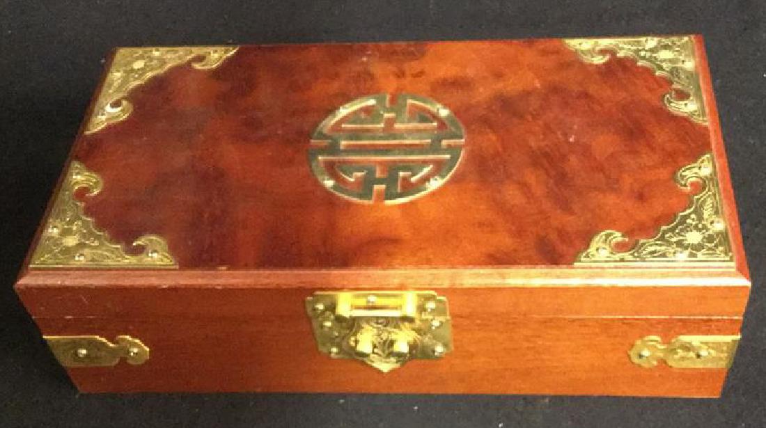 Wood And Brass Chinese Jewelry Box Jewelry box is: Jewelry box is decorated in brass and has a brass latch and brass corners. Inside the jewelry box is one compartment with a mirror on inside top. Measures 3-3/4" h x 11-1/2" l x 6" w