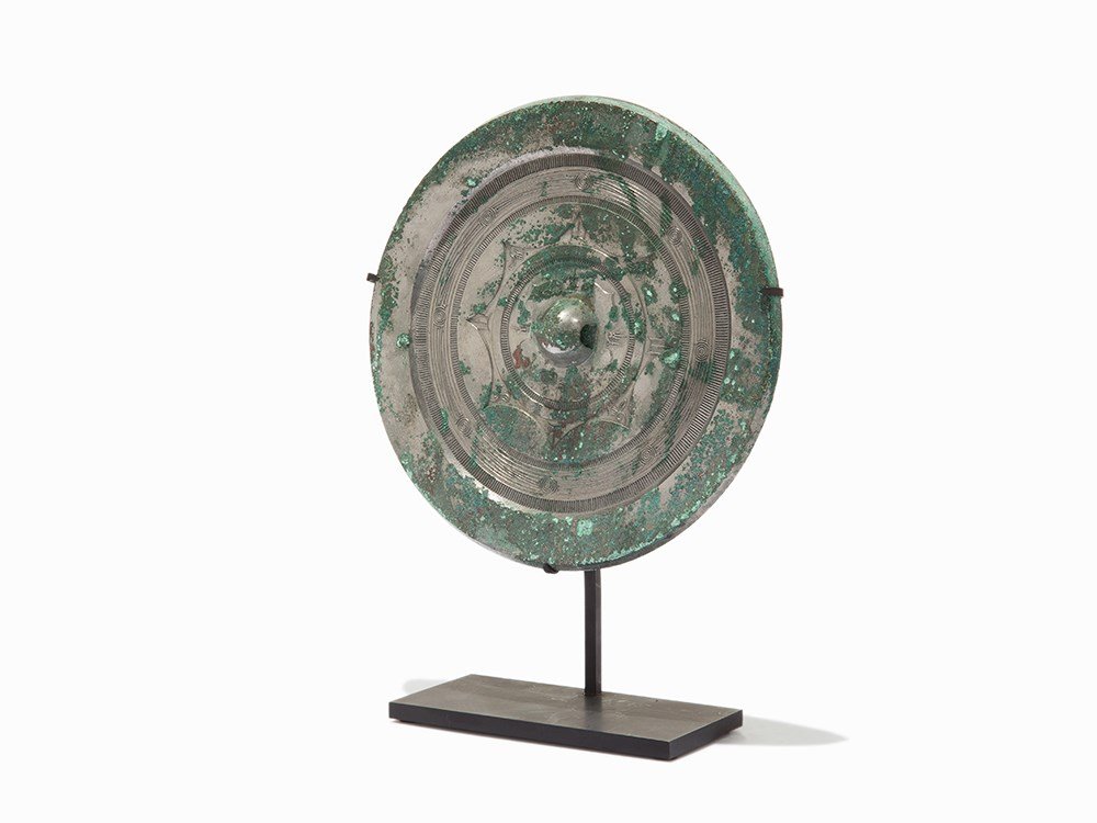 Chinese Silvered Bronze Mirror, Han Dynasty: Silvered and bronze accompanied with a recent metal stand China, Han Dynasty (206 BC – 220 AD) Central knob is surrounded by pictograms Decorated with linear and geometrical patterns Beautiful malac