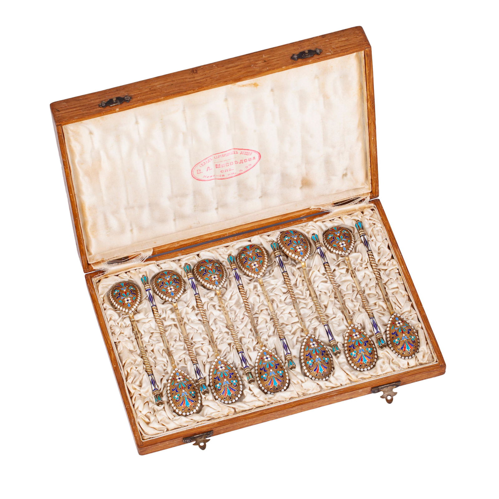 A Russian silver-gilt and cloisonne enamel tea spoons: A Russian silver-gilt and cloisonne enamel tea spoons set (12 pc). In original case of the V.A.Myasoedov trade house. Makers mark of I. Saltikov. Moscow, the end of the 19th century. Total spoons weig