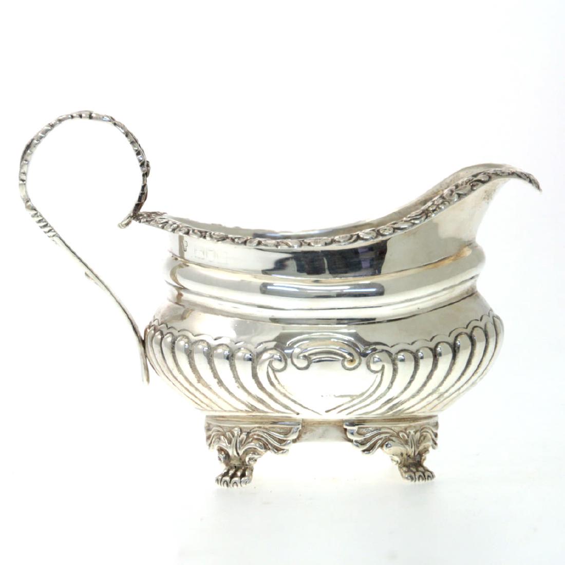 Sterling Silver Creamer Milk Jug, Charles Stuart: Sterling Silver Creamer Milk Jug, Charles Stuart Harris, London, England, 1902. With fluted ornaments. Upper rim with chased floral and foliage ornaments. Set on four paw shape supports. A