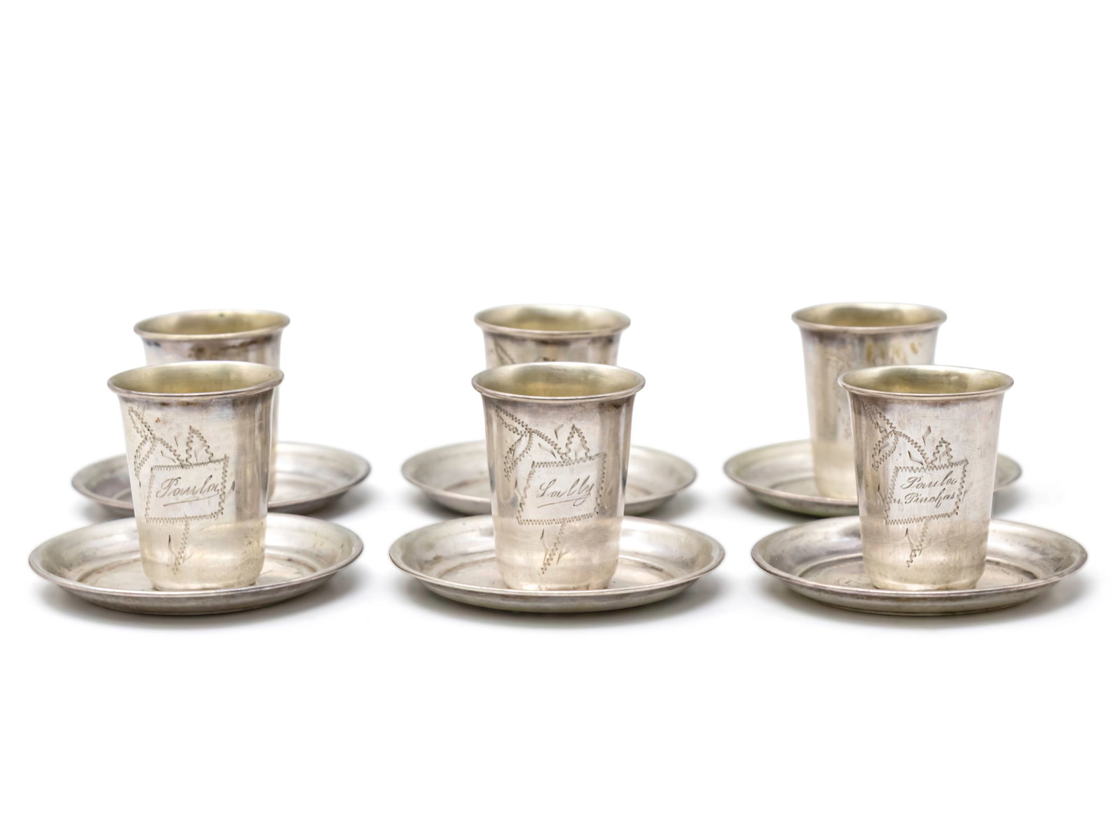 Set of Six Silver Tots and Coasters.: Set of Six Silver Tots and Coasters. Engraved ornaments. Marked (84P). Tot height: 4.5cm. Coaster diameter: 7cm. 177gr.