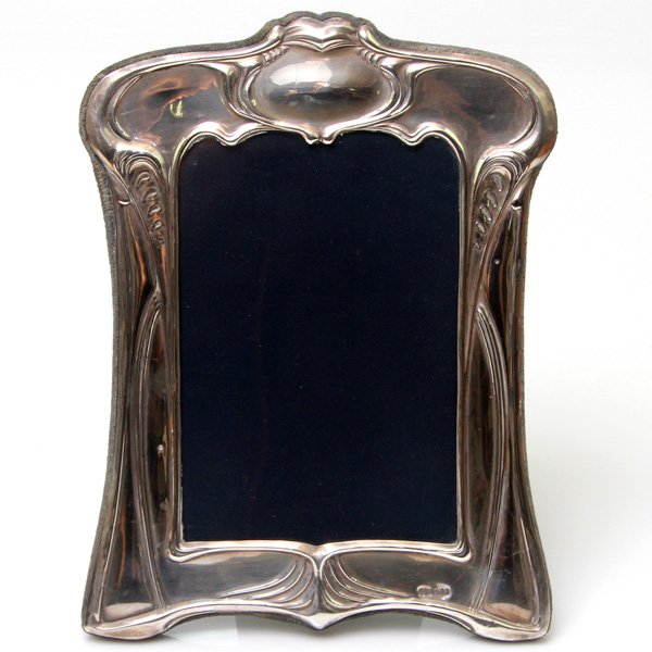 Sterling Silver Photo Frame By Carr's of Sheffield: Sterling Silver Photo Frame By Carr's of Sheffield. Of typical Art Nouveau style, topped with a vacant cartouche. Easel frame covered with blue velvet. Can take a photo up to 14cm X 9cm / 5.5in X 3.54