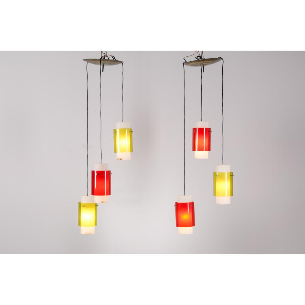 HARVEY GUZZINI, Coppia di lampade a sospensione: HARVEY GUZZINI Produzione Italia 1960 ca. Coppia di lampade a sospensione a 3 luci, struttura in rame smaltato, diffusori cilindrici in perspex bianco, rosso e giallo, Collezione Harvey Guzzini, prodo