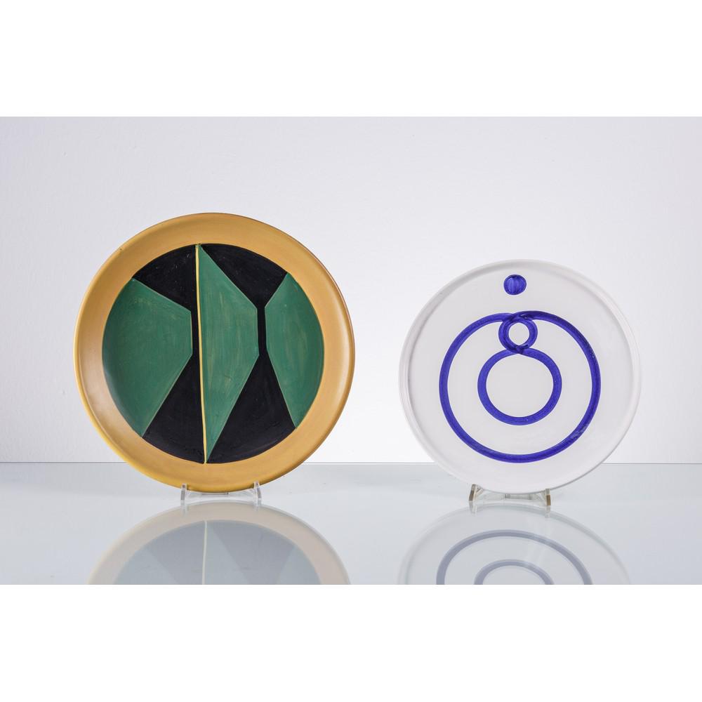 MARCO TIRELLI E ‘LA GIOCONDA’ DERUTA, Due piatti: MARCO TIRELLI E ‘LA GIOCONDA’ DERUTA Produzione Italia 1960 ca. Due piatti dipinti a mano, uno verde e nero in argilla rossa firmato Marco Tirelli (22/420), l'altro in argilla bianca smalt