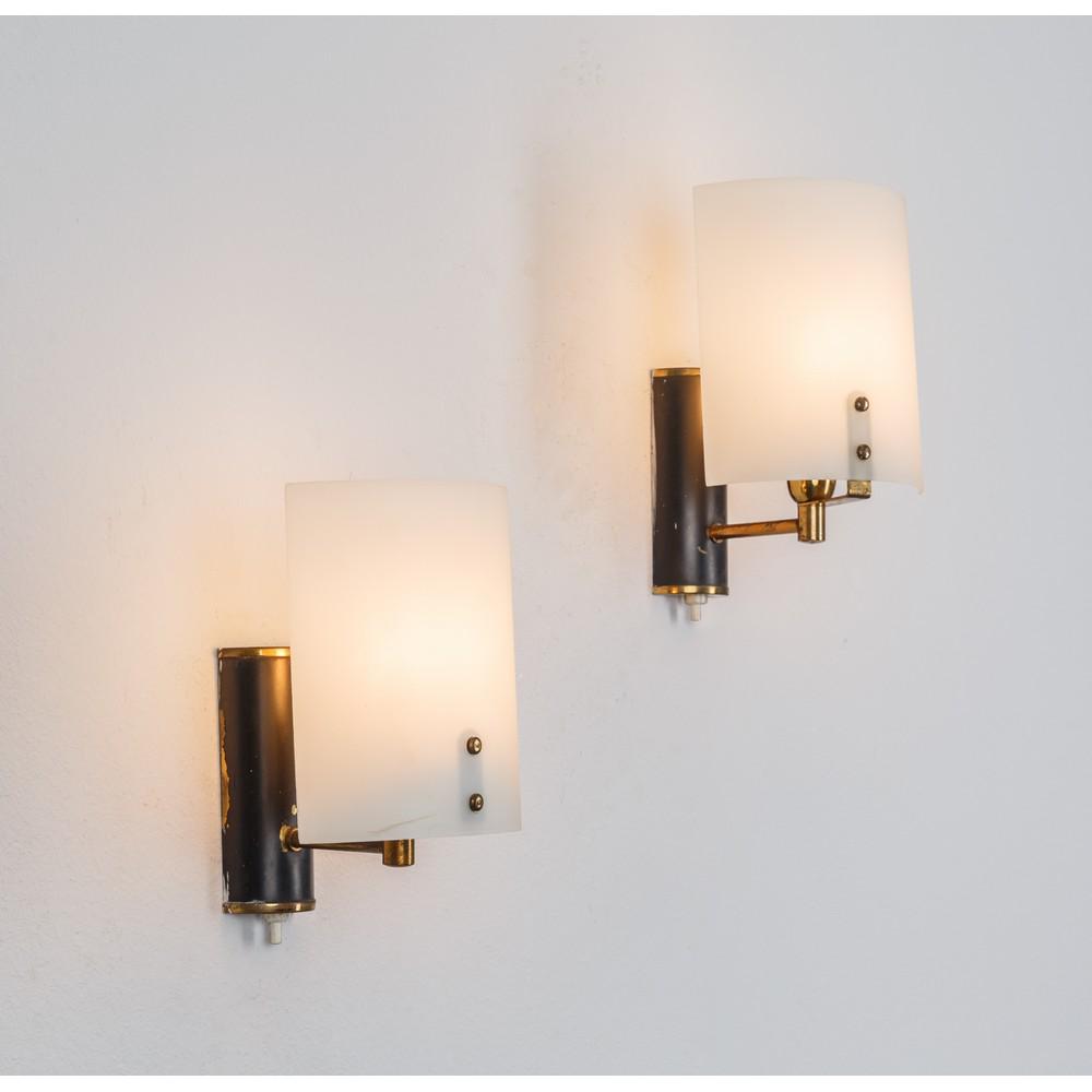 STILUX MILANO, Coppia di lampade da parete: STILUX MILANO Produzione Italia 1960 ca. Coppia di lampade da parete ad una luce, struttura in metallo verniciato nero, ottone, diffusori curvati in vetro satinato bianco. cm 14 x 12 x 20. A PAIR WALL