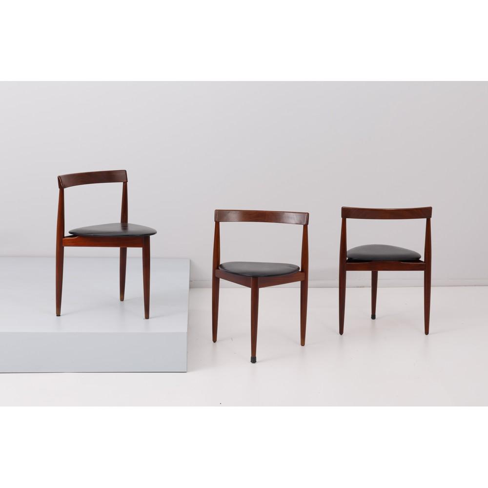 HANS OLSEN, Tre sedie in legno: HANS OLSEN Produzione Frem Rojle, Danimarca 1950 ca. Tre sedie in legno di teak, seduta triangolare rivestita in skai nero, spalliera curva in legno, piede conico, marchio di produzione, segni di usur