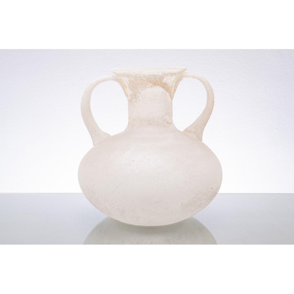 MAESTRI MURANESI, Vaso ad anfora in vetro: MAESTRI MURANESI Produzione Italia 1960 ca. Vaso ad anfora in vetro scavo lattimo, corpo globulare, collo schiacciato, due anse, bocca piana. cm 27,5 x 33 x Alt. 31,5 .