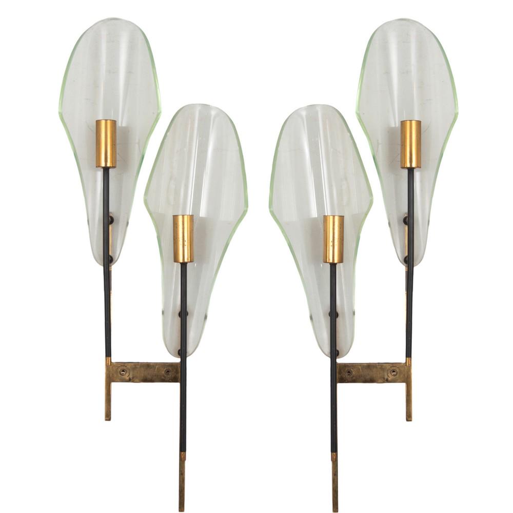 PRODUZIONE ITALIANA 1960 ca. Coppia di lampade da parete: PRODUZIONE ITALIANA 1960 ca. Coppia di lampade da parete a due luci, struttura in metallo verniciato nero ed ottone, diffusore sagomato in vetro trasparente. Alt. cm 61.