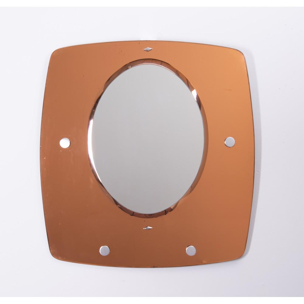 VECA (Attr.le), Specchio de parete: VECA (Attr.le) Produzione Italia 1970 ca. Specchio de parete con corpo rettangolare in cristallo color ambra specchiato e molato con inserto ovale in cristallo specchiato. cm 100 x 95. A WALL MIRROR A
