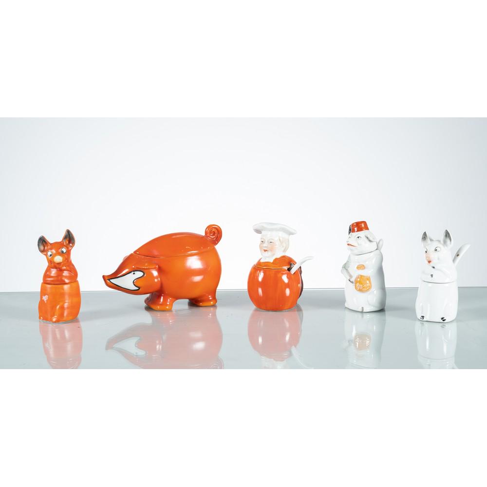 PRODUZIONE EUROPEA 1950 ca., Cinque complementi da tavola: PRODUZIONE EUROPEA 1950 ca. Cinque complementi da tavola in ceramica decorata nei toni arancio e bianco, quattro porcellini ed un cuoco. Cm 14,5 x 8 Alt. 8,5 Max. FIVE EUROPEAN TABLE ACCESSORIES.