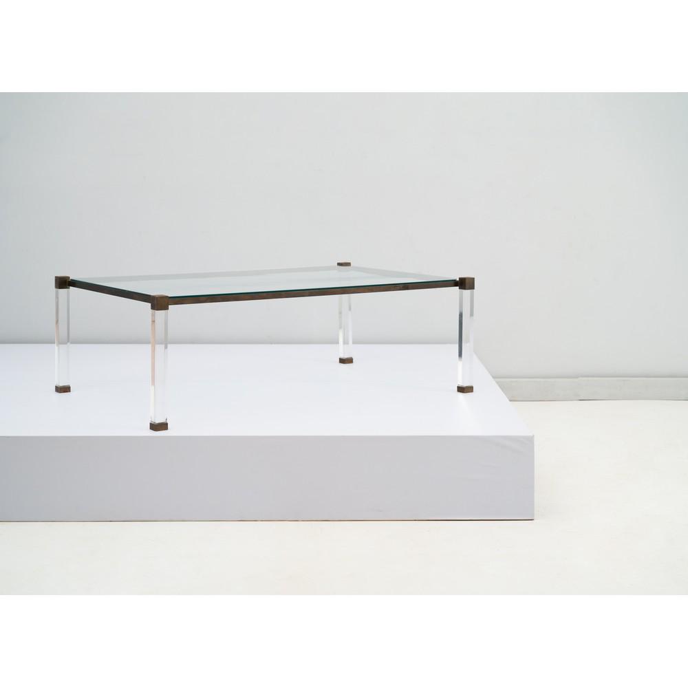 PIERRE VANDEL, Tavolo basso: PIERRE VANDEL Produzione Francia 1975 ca. Tavolo basso in lucite trasparente e ottone, piano rettangolare in vetro trasparente, piedi quadrangolari. Cm 80 x 120 Alt. 40. Pubblicazione catalogo altra c