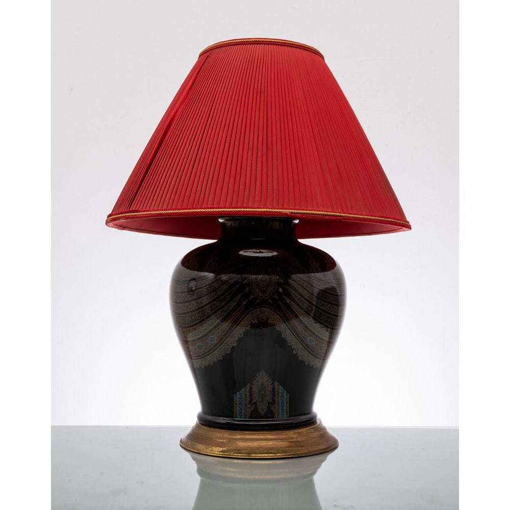 ETRO, Lampada da tavolo: ETRO Produzione Italia 1970 ca. Lampada da tavolo ad una luce in ceramica nera con decoro policromo paisley, base circolare in metallo dorato, paralume in tessuto plissè nei toni del rosso. March
