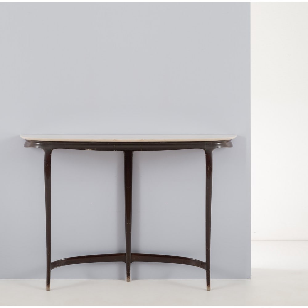 CARLO ENRICO RAVA, Consolle: CARLO ENRICO RAVA Produzione Marelli & Colico, Italia 1950 ca. Consolle in legno ebanizzato, sostegni in legno scolpito e piano curvato in marmo. Segni d’uso. cm 134 x 30 Alt. 92. Bibliografia: