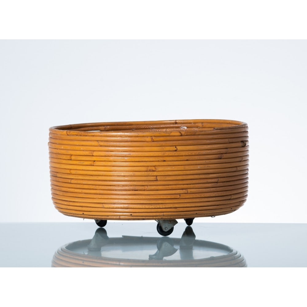PRODUZIONE ITALIANA 1960 ca., Cachepot: PRODUZIONE ITALIANA 1960 ca. Cachepot circolare in canna di bambù a montaggio orizzontale, base circolare in legno laccato su quattro ruote. cm Ø 40 Alt. 21.