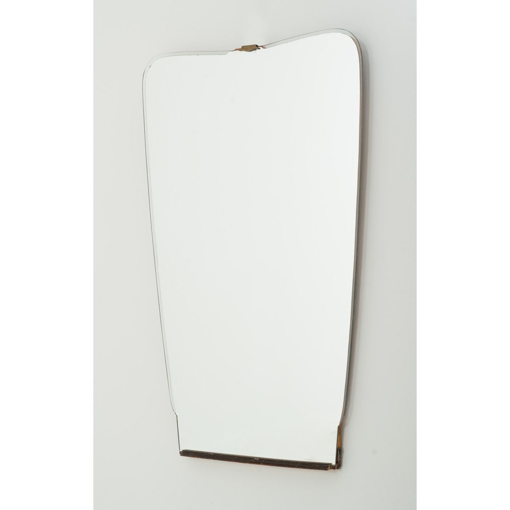 PRODUZIONE ITALIANA 1950 ca., Specchio: PRODUZIONE ITALIANA 1950 ca. Specchio d'appoggio o parete in cristallo sagomato e specchiato, cornice in cristallo trasparente, struttura in legno, decoro superiore in ottone. Ossidazioni e segni di u