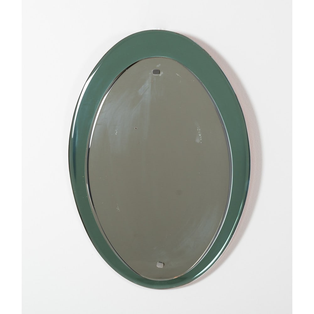 VECA (Attr.le), Specchio da parete: VECA (Attr.le) Produzione Italia, 1960 ca. Specchio da parete ovale con cornice in vetro molato fumè grigio, cristallo specchiato, minuterie in metallo cromato. Ossidazioni e segni di uso. cm 71