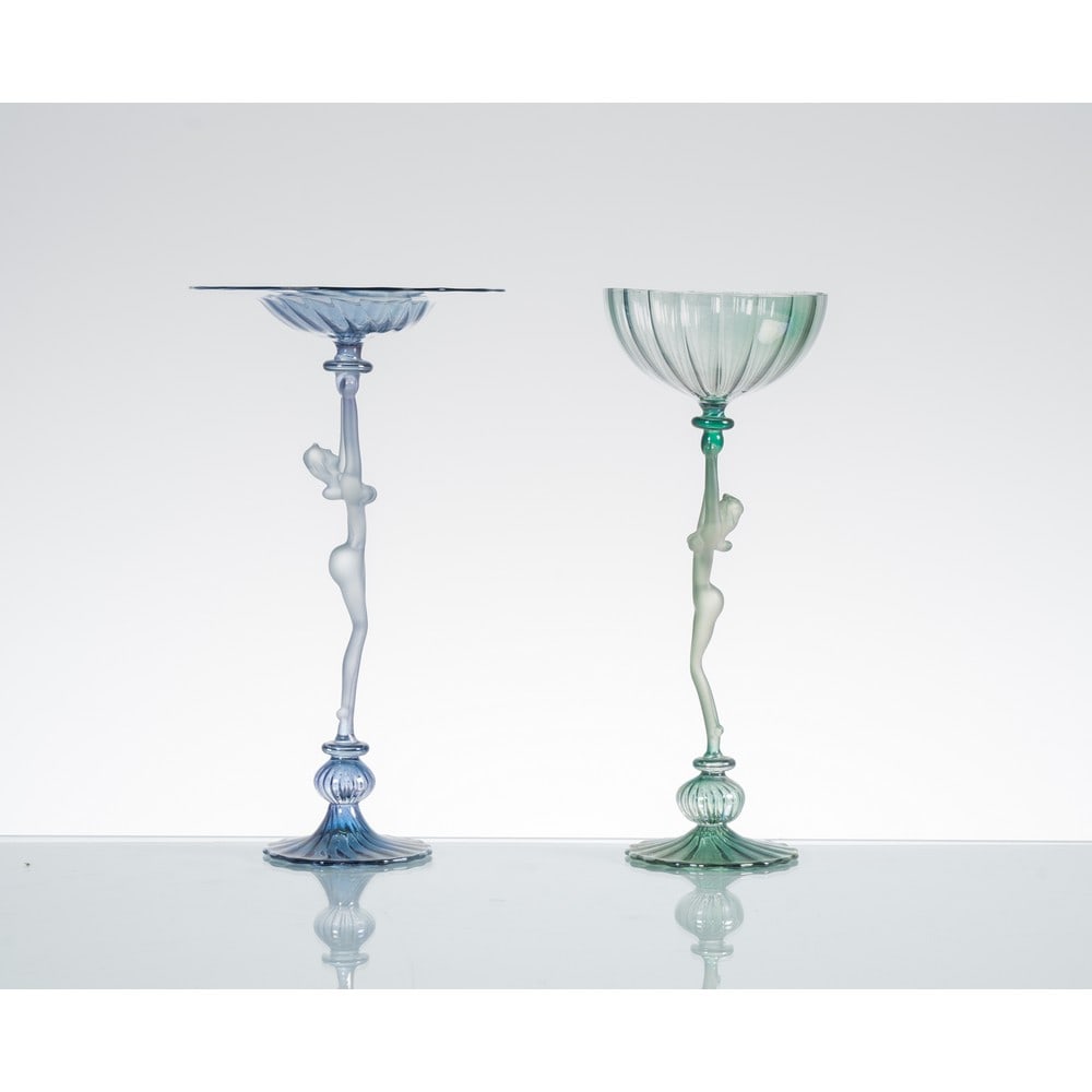 LA MURRINA, Collezione di due bicchieri in vetro: LA MURRINA Produzione Murano, Italia 1980 ca. Collezione di due bicchieri in vetro soffiato uno azzurrino e uno verde, gambo con figura femminile con coppa sovrastante in vetro lievemente costolato. F