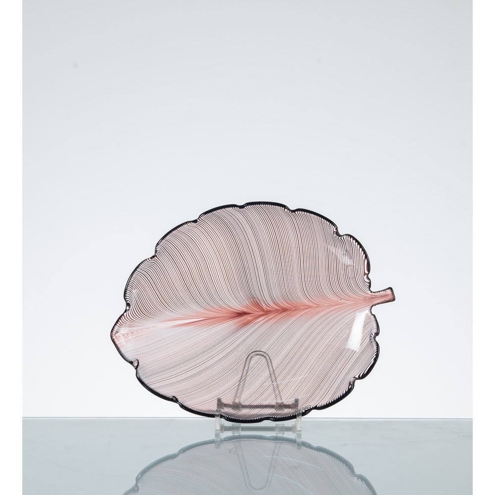 TYRA LUNDGREN, Foglia in vetro: TYRA LUNDGREN Produzione Venini, Italia 1983 ca. Foglia in vetro a mezza filigrana incolore e seppia, disegno anni' 30. Etichetta di produzione e firma a graffio "Venini Italia 83". cm 27 x 21 Alt. 3,