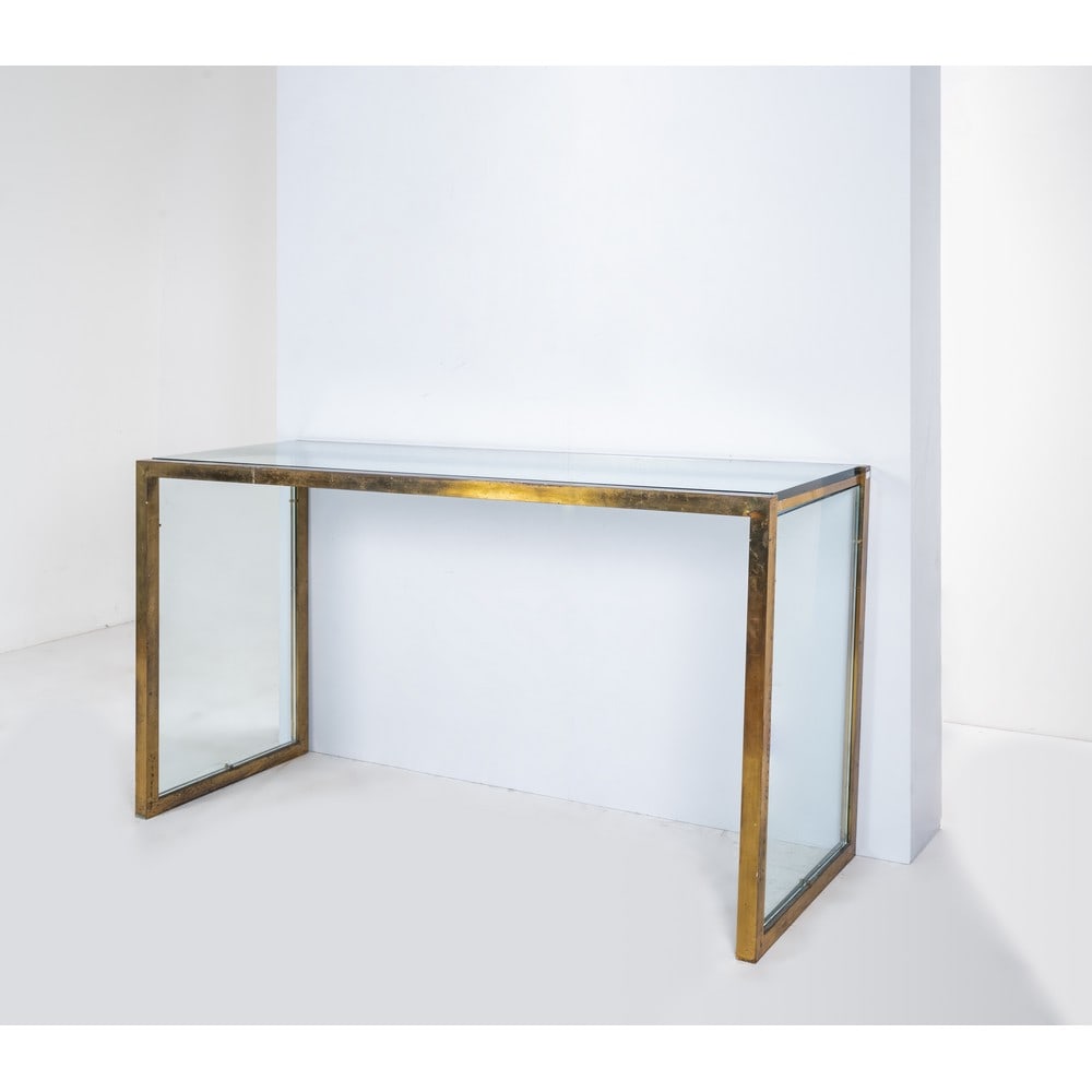 NANDA VIGO, Consolle: NANDA VIGO Produzione Italia 1970 ca. Consolle con struttura in ottone, piano rettangolare in cristallo di grosso spessore. Sbeccatura al cristallo, ossidazioni all'ottone. cm 170 x 60 Alt. 89. Biblio