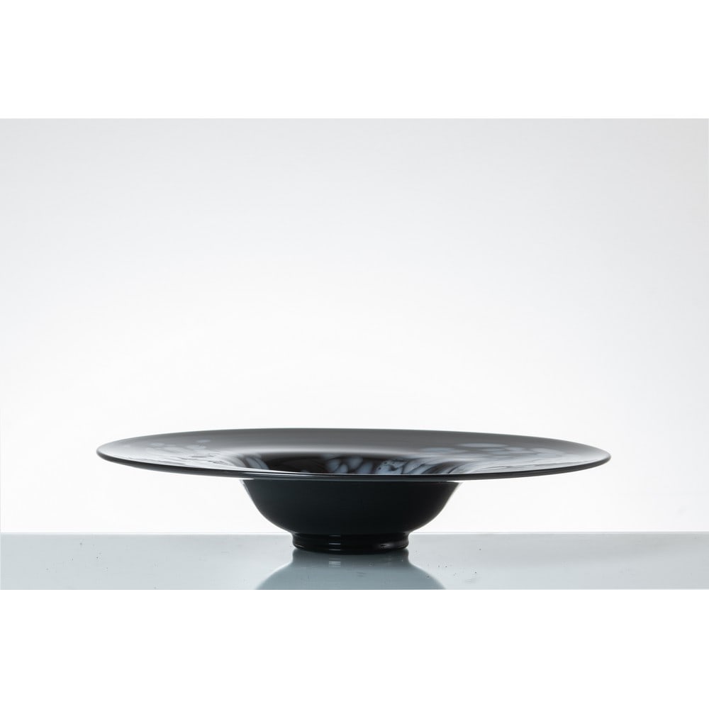 LA MURRINA (Attr.le), Piatto circolare in vetro: LA MURRINA (Attr.le) Produzione Murano, Italia 1970 ca. Piatto circolare in vetro nero decorato con murrine lattine a decoro informe. Cm Ø 45 Alt. 8,5.