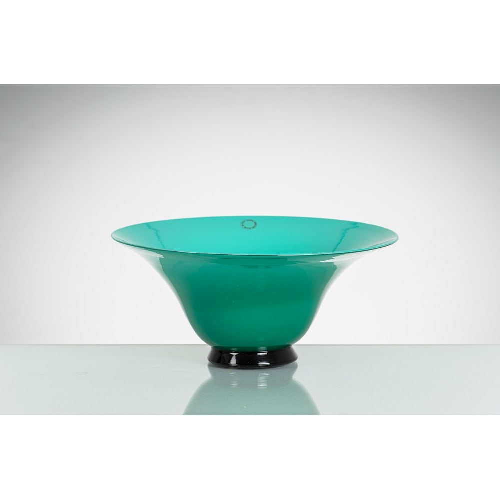 PAOLO VENINI, Coppa della serie “Anni Trenta” in vetro: PAOLO VENINI Produzione Venini, Italia 1991 ca. Coppa della serie “Anni Trenta” in vetro opalino verde con base circolare nera. Etichetta, firma e data a graffio. cm Ø 25,5 Alt. 12. B