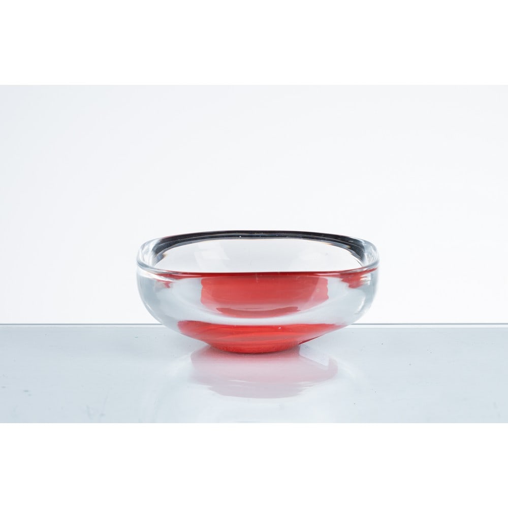 PIERRE CARDIN, Ciotola in vetro: PIERRE CARDIN Produzione Venini, Italia 1979 ca. Ciotola in vetro trasparente con inclusione di vetro colorato rosso. Firma a graffio. cm 11,5 Alt. 4,5. Bibliografia: Catalogo altra casa d’aste.