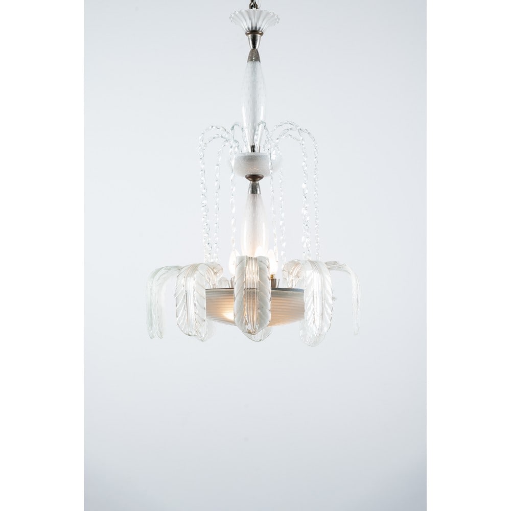 ERCOLE BAROVIER, Lampada a sospensione: ERCOLE BAROVIER Produzione Barovier 1940 ca. Lampada a sospensione a sette luci, struttura in metallo e vetro incolore, corpo a fontana, diffusore a disco in vetro pulegoso e decorato a spirale con fo