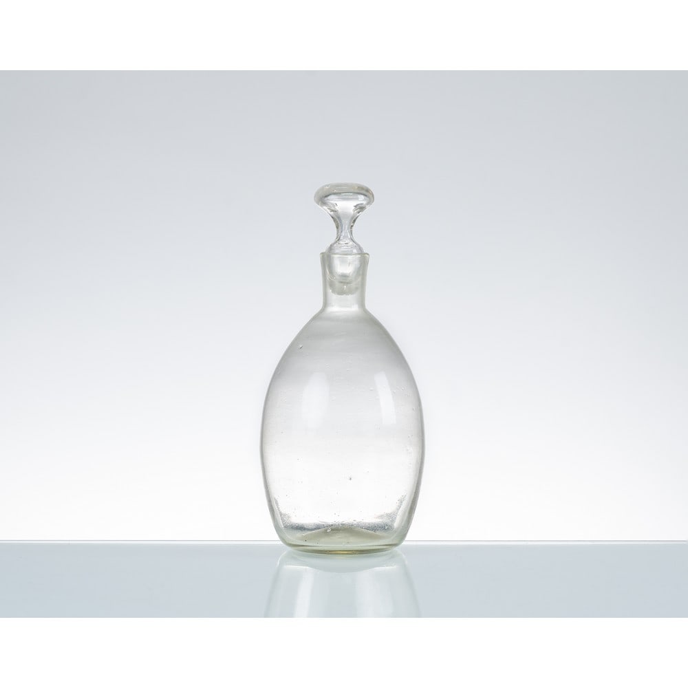 CARLO SCARPA, Bottiglia in vetro: CARLO SCARPA Produzione Venini & C, Italia 1936 ca. Bottiglia in vetro soffiato pulegoso, corpo ovalizzato con collo cilindrico, bocca piana circolare, tappo circolare. cm Alt. 24. A GLASS BOTTLE BY C