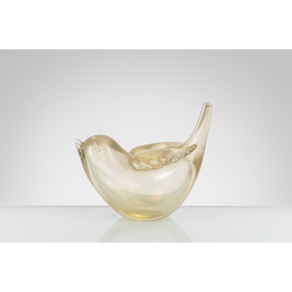 TYRA LUNDGREN, Figura di uccello modello “2627” in vetro: TYRA LUNDGREN Produzione Venini 1946 ca. Figura di uccello modello “2627” in vetro paglierino iridescente. Sbeccatura sul becco. cm 10,5 x 7 Alt. 9. Bibliografia: M. Barovier e C. Sonego,