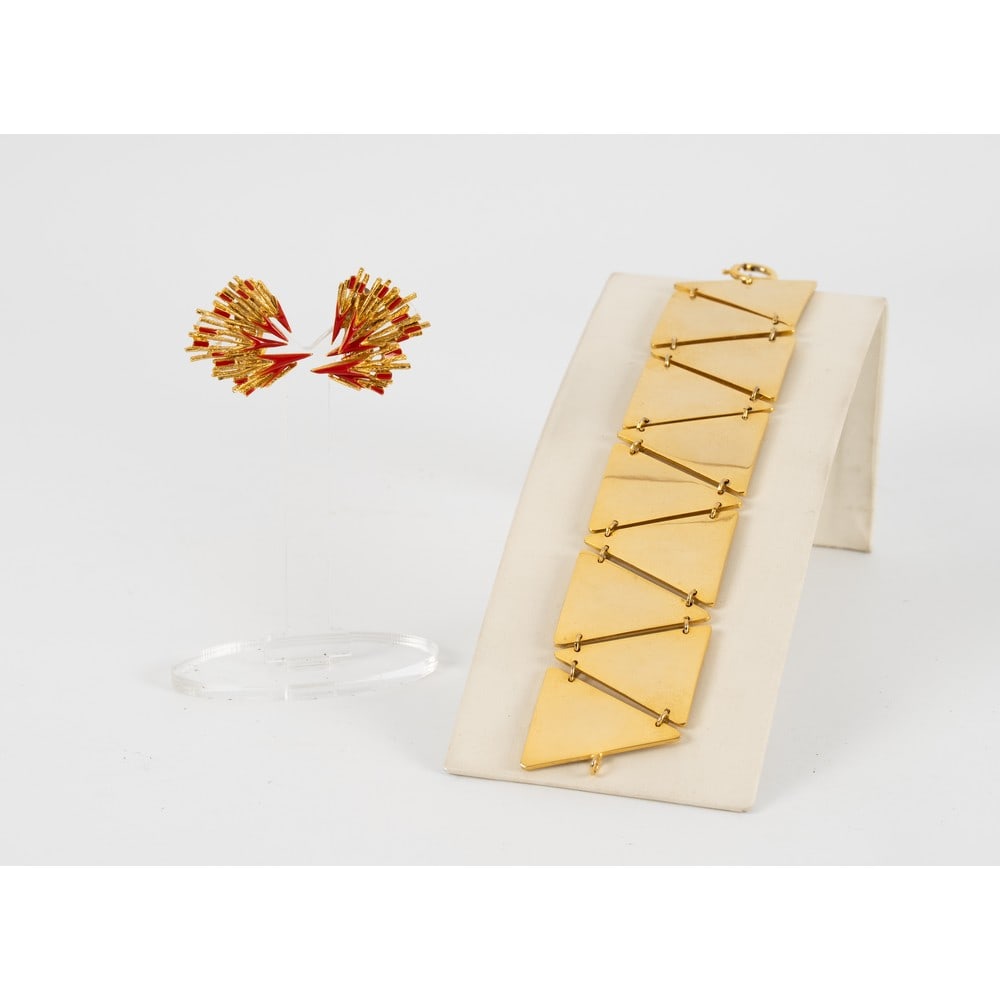 ORENA E PRODUZIONE ITALIANA, Orecchini e bracciale: ORENA E PRODUZIONE ITALIANA Produzione Francia 1970 ca. e 1980 ca. Orecchini con montatura in metallo dorato, smalti rossi, chiusura a clips. Marchio di produzione. Bracciale semi rigido con montatura