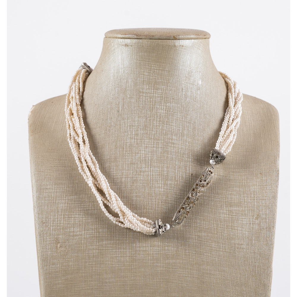 CARLO ZINI, Girocollo in microperline: CARLO ZINI Produzione Italia 1970 ca.Girocollo in microperline, montatura in metallo argentato, placca centrale con diamanti sintetici, chiusura a grilletto. Mancanze. Marchio di produzione.