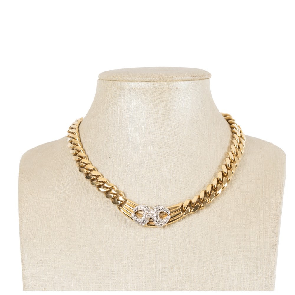 VOGUE BIJOUX, Collana con montatura in metallo dorato: VOGUE BIJOUX Produzione Italia 1990 ca.Collana con montatura in metallo dorato, catena a maglia piatta, centrale con decoro in diamanti sintetici taglio brillante, chiusura a cassetta. Marchio di prod