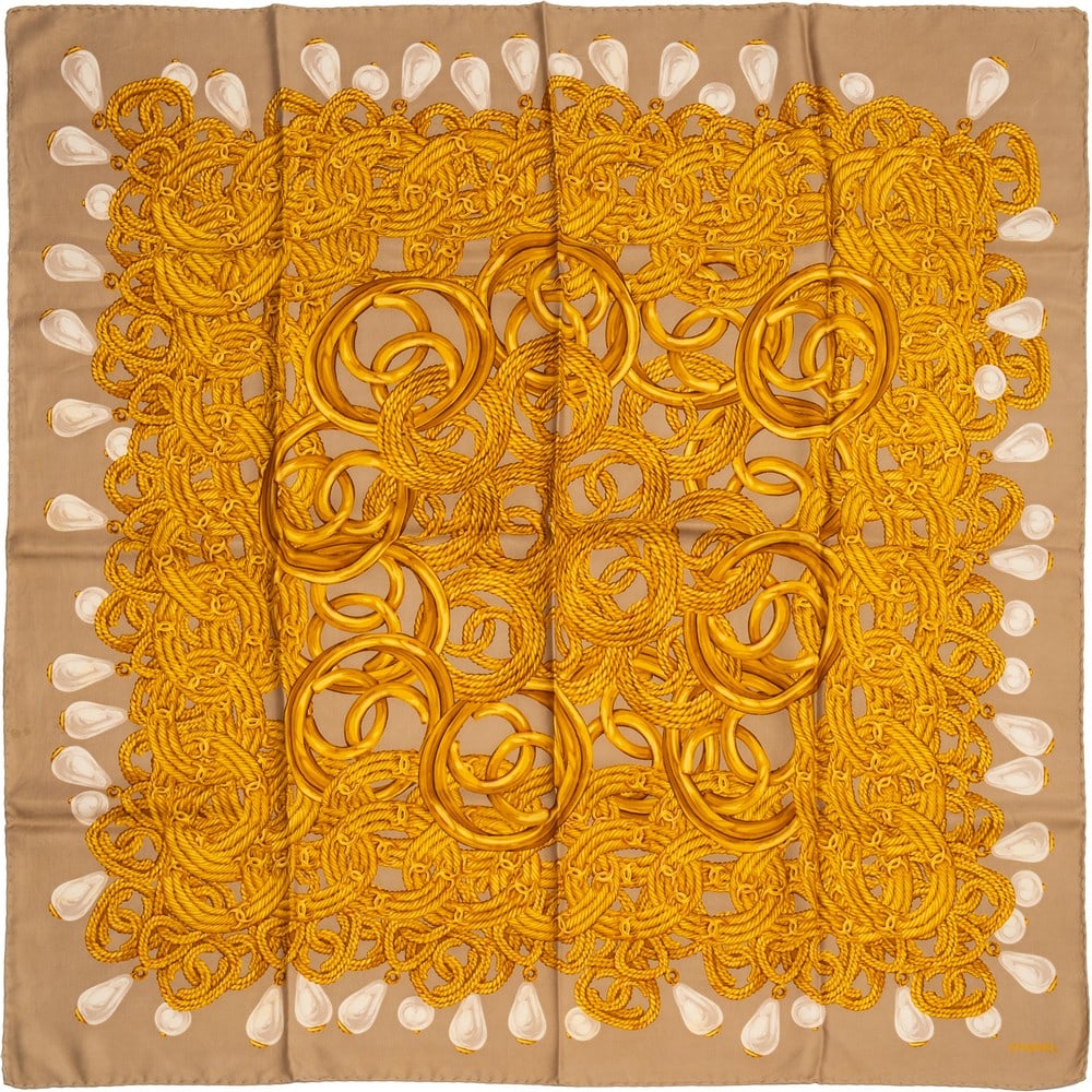 CHANEL, Foulard in pura seta: CHANEL Produzione Francia 1990 ca. Foulard in pura seta decorato con catene ocra e perle su fondo tortora. Lievi macchie. Marchio di produzione. cm 90 x 90.