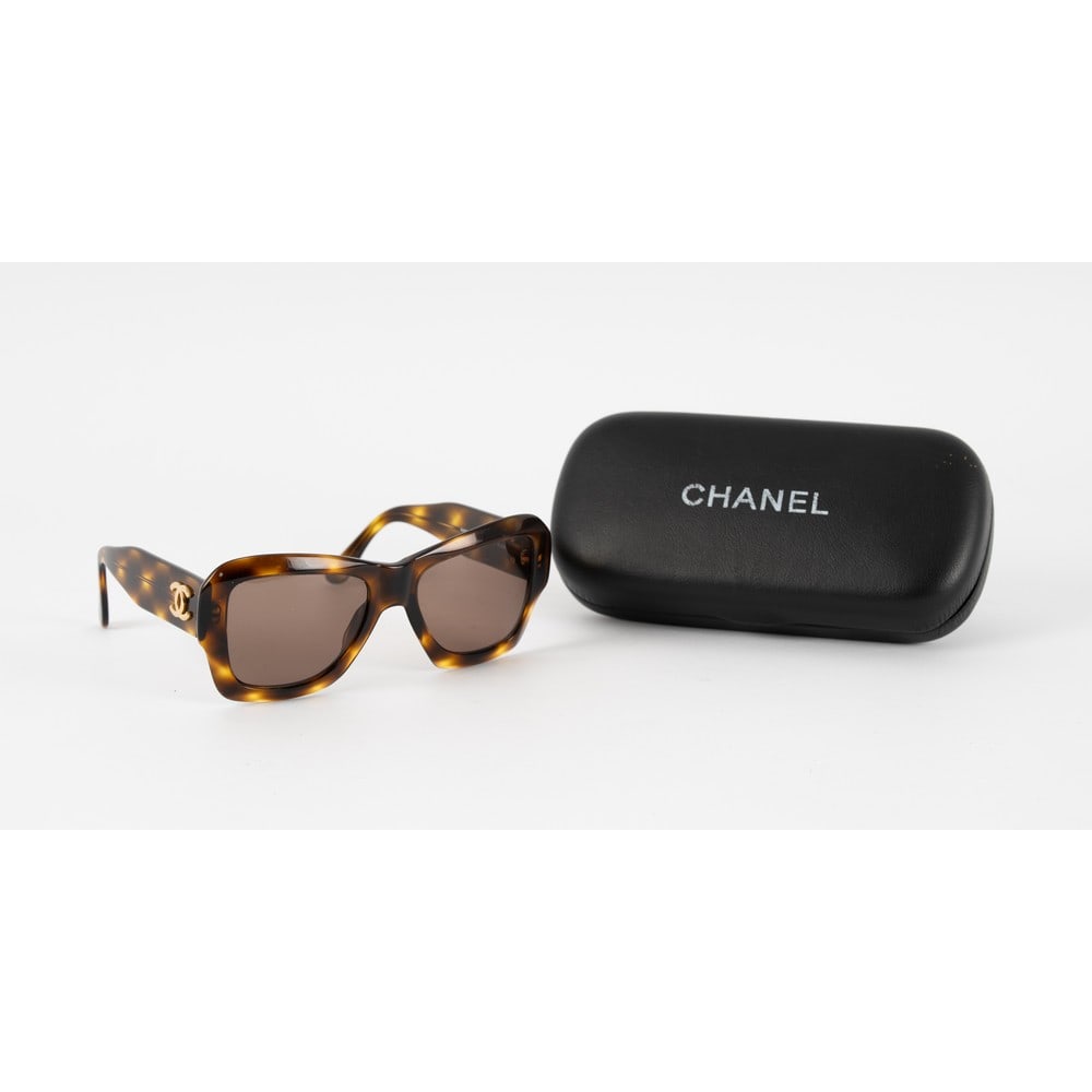CHANEL, Occhiale da sole modello “02464: CHANEL Produzione Francia 2000 ca. Occhiale da sole modello “02464”, montatura in acetato ad effetto tartaruga, lenti brown, aste larghe, logo “CC” in metallo dorato. Marchio di produz