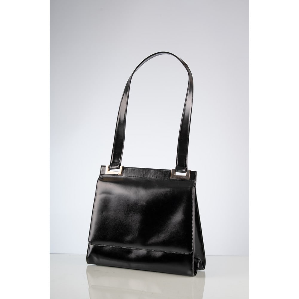 GUCCI, Borsa a spalla: GUCCIProduzione Italia, 1990 ca. Borsa a spalla in vitello spazzolato nero, manico piatto, minuterie legate in metallo cromato, chiusura a scatto sulla patta frontale, due scomparti interni di cui uno