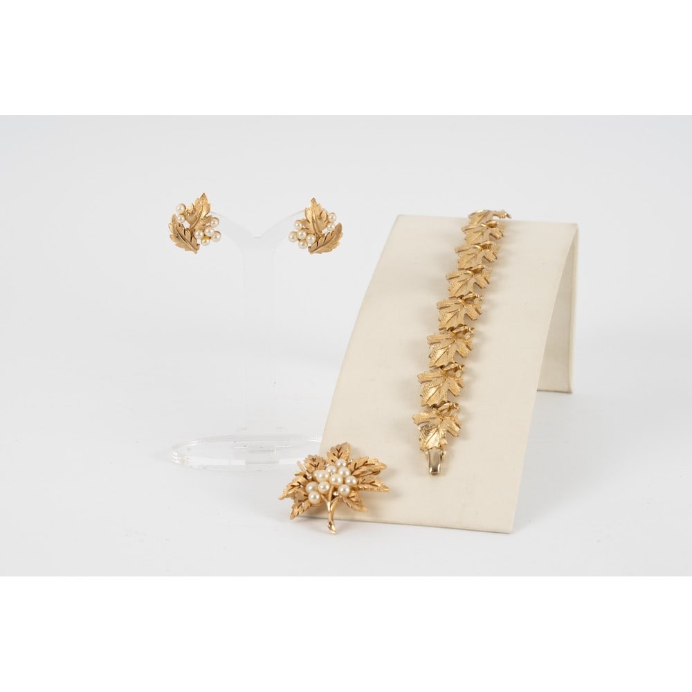 TRIFARI, Parure composta da tre pezzi: TRIFARI Produzione U.S.A. 1960 ca.Parure composta da tre pezzi; un bracciale semi rigido con montatura in metallo dorato, foglie concatenate una con l’altra, chiusura a fermaglio . Marchio di produz