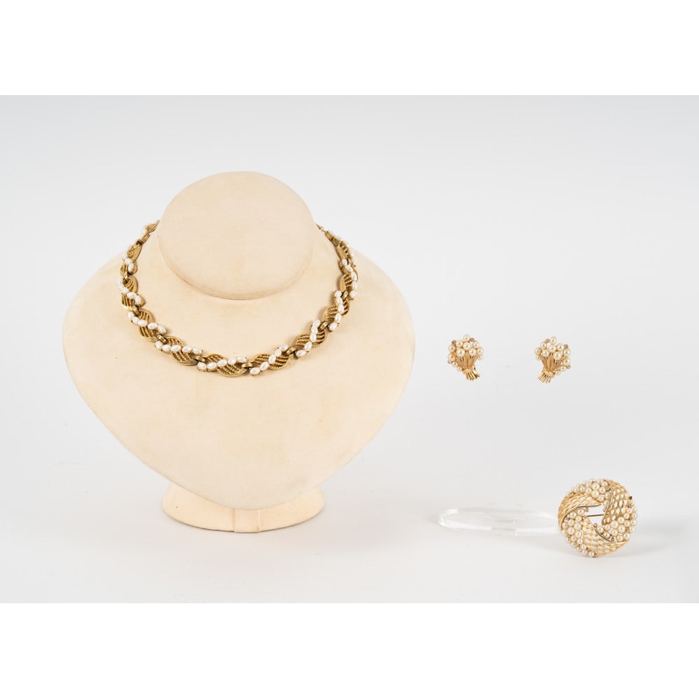 TRIFARI, Parure composta da tre pezzi: TRIFARI Produzione U.S.A. 1960 ca.Parure composta da tre pezzi; un girocollo semi rigido con montatura in metallo dorato, elementi ad ondine concatenate, perle, chiusura a gancio ad S. Marchio di prod